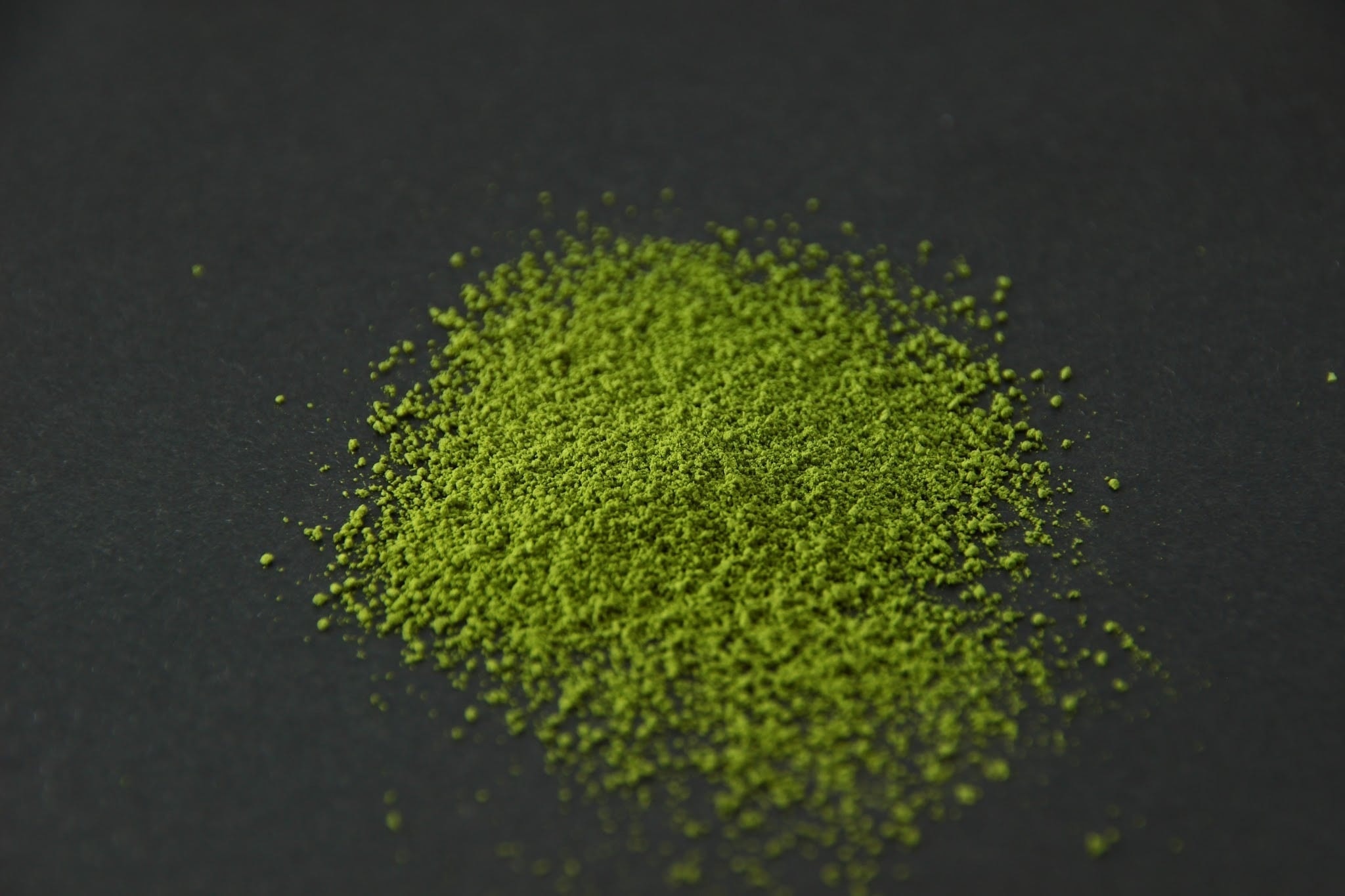AKOG matcha powder heaped on a dark surface
