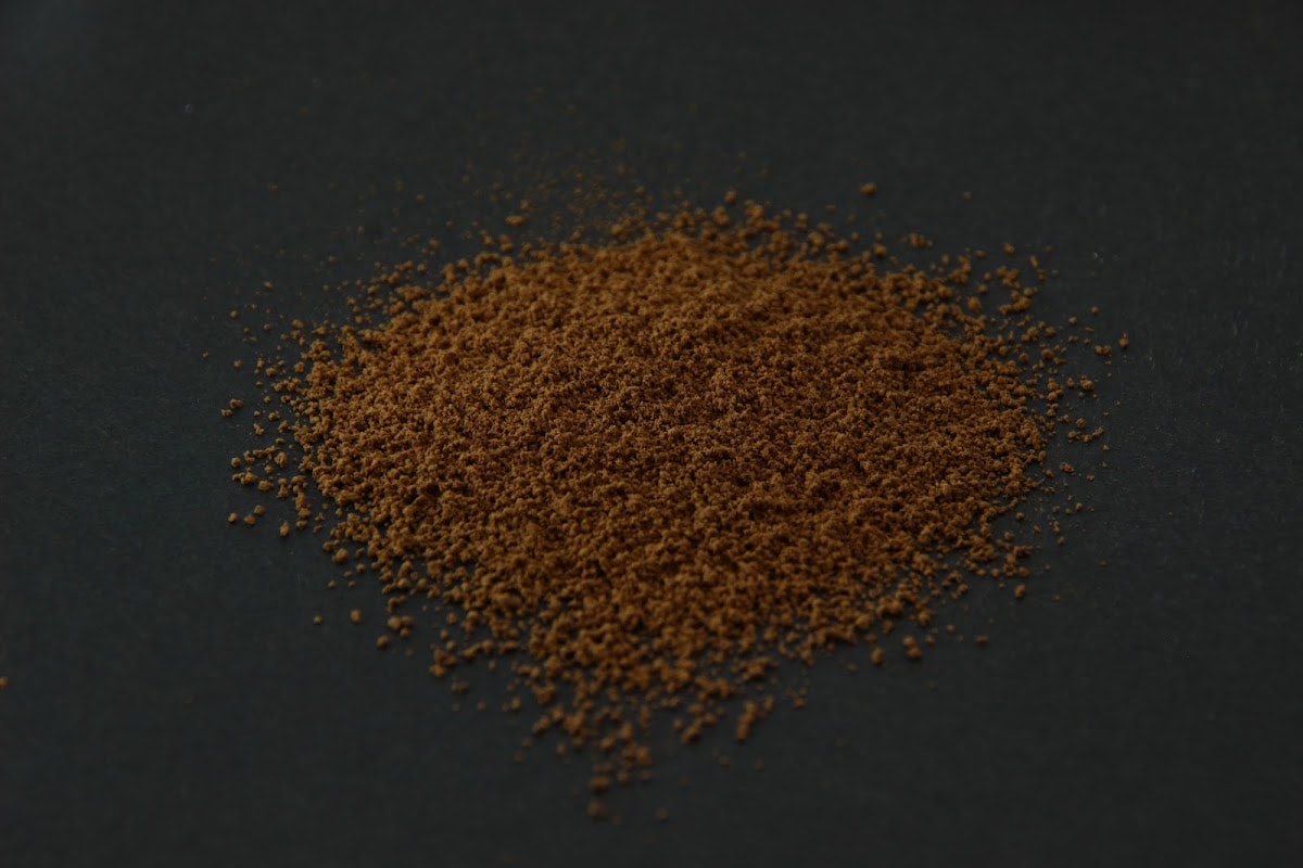 Dark brown KS-HOJ hojicha powder heaped on a dark surface